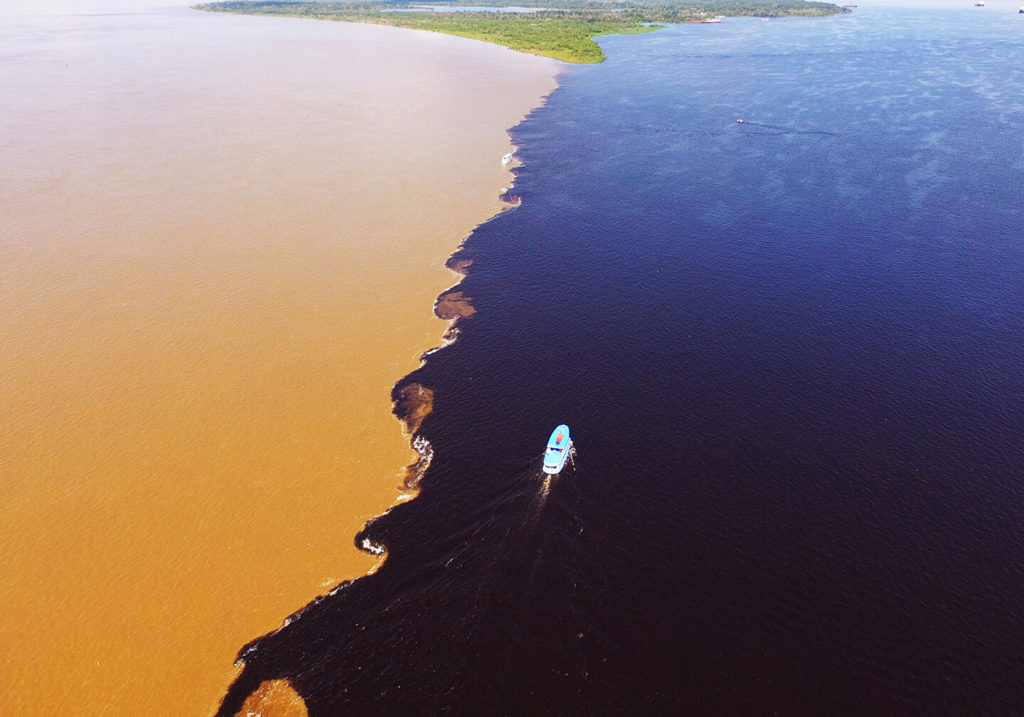 Luftaufnahme eines Bootes am Zusammenfluss von Rio Negro und Amazonas.
